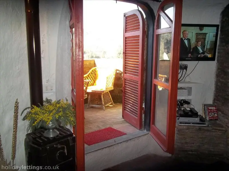 La porta rossa del soggiorno aperta sul balcone della casa