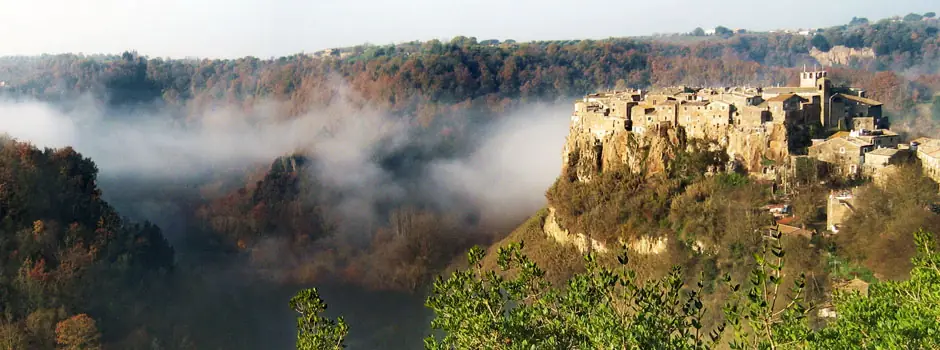 Il borgo di Calcata sulla rupe, circondato dai boschi e dalla nebbia